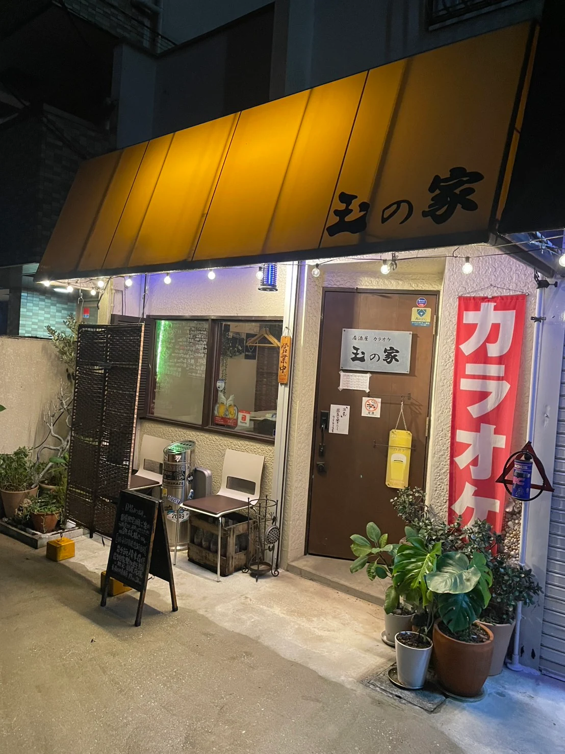 黄色いひさしとカラオケののぼりが目印の玉の家の外観